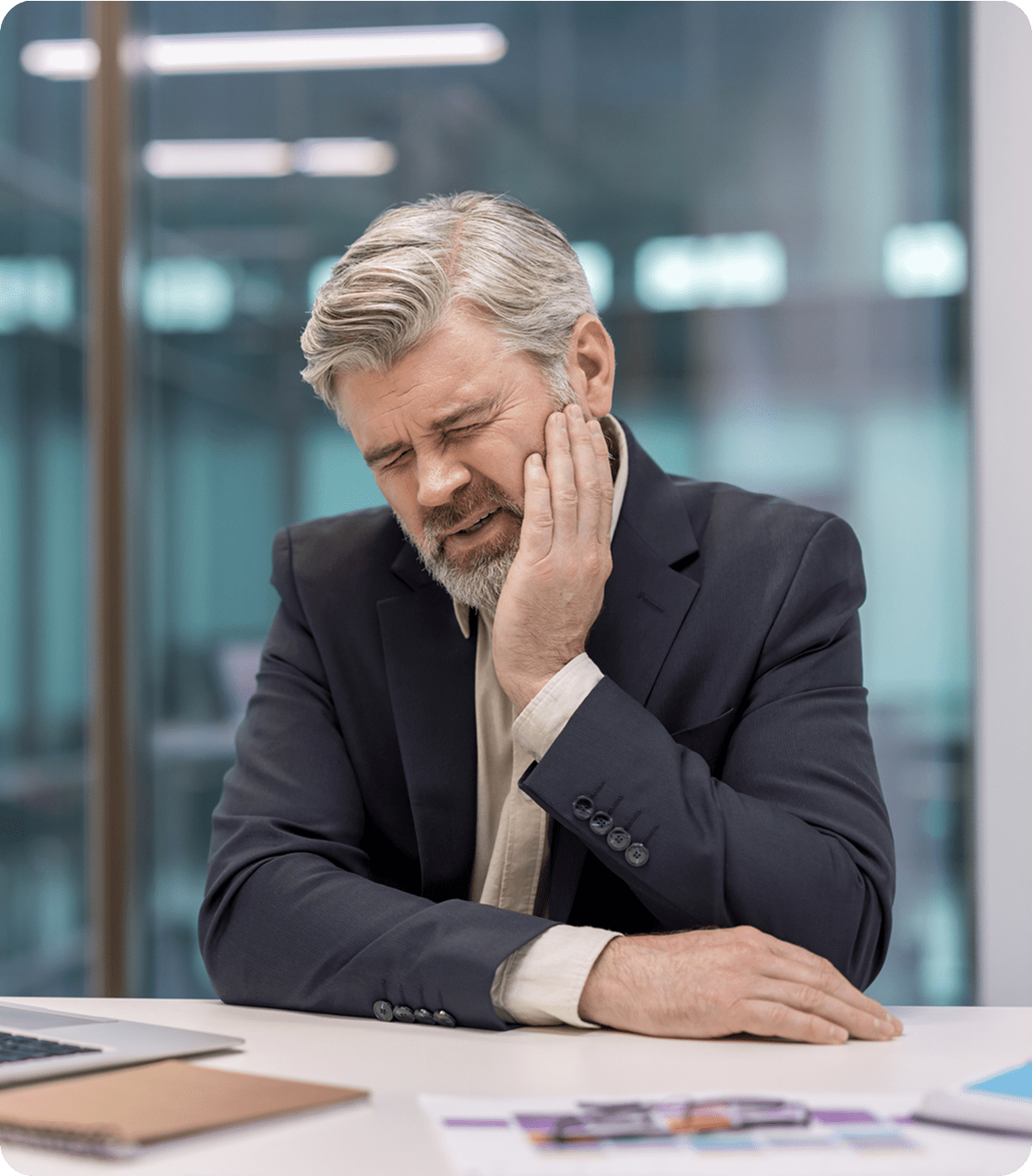 Man experiencing toothache at office desk